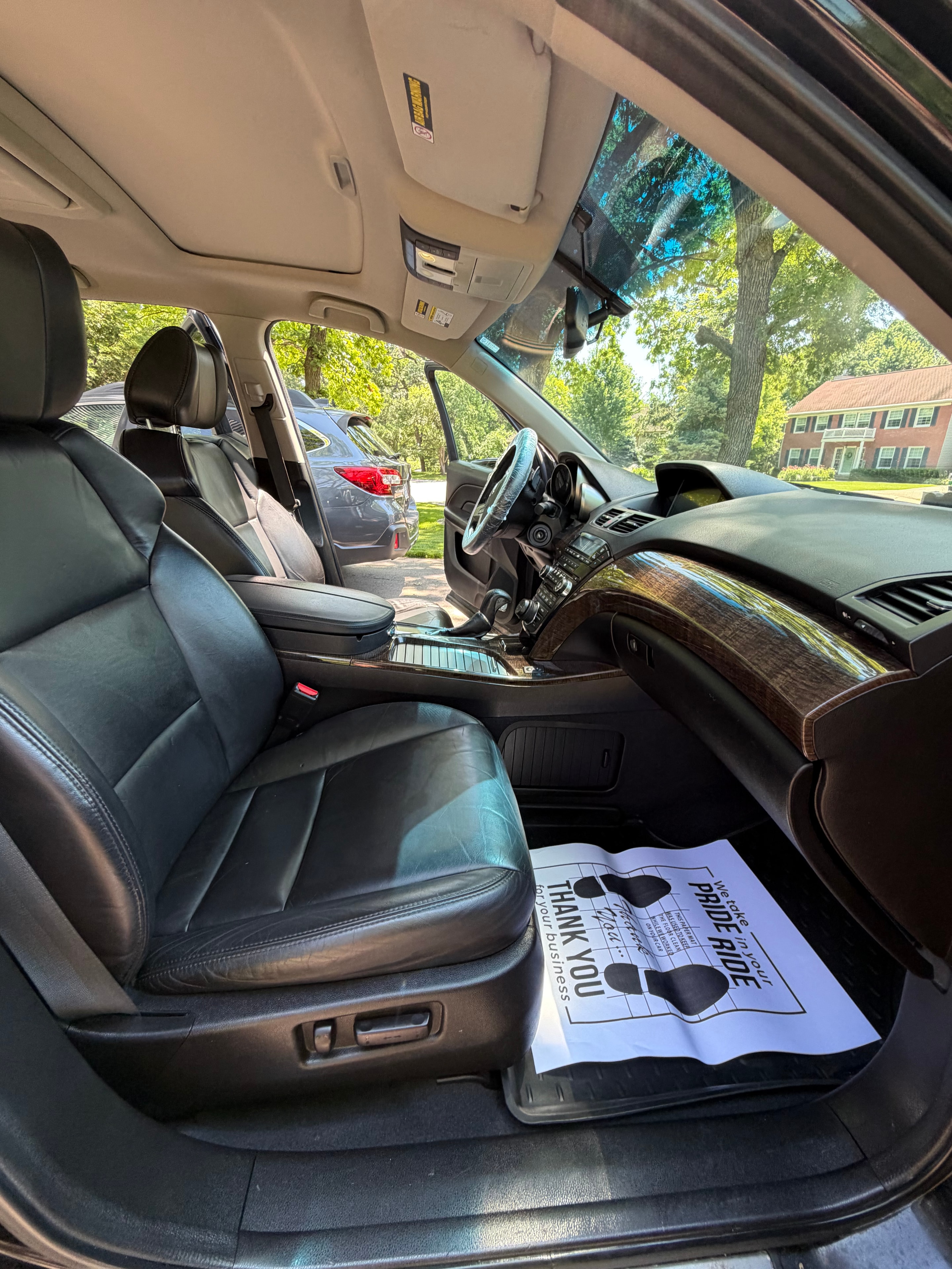 Interior detail — black leather cabin with thank you card